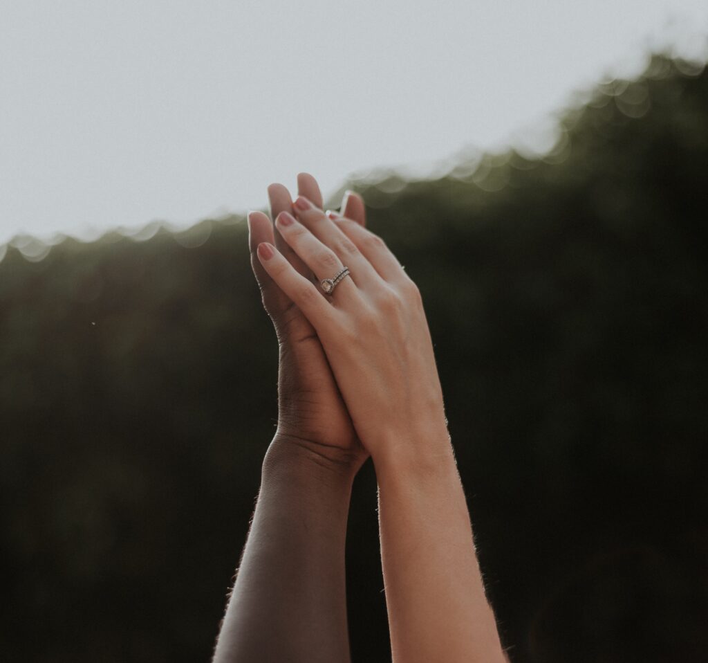 Two people of different ethnicities showing solidarity by holding hands