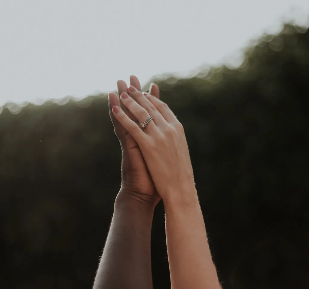 Two people of different ethnicities showing solidarity by holding hands