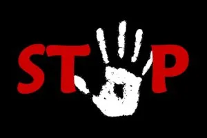 The word 'stop' in capital letters in red on a black background. The 'o' is replaced by a white handprint. Stop disability benefit cuts!